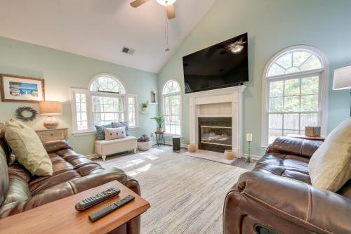 a living room with two leather couches and a flat screen tv at Pet-Friendly LaGrange Vacation Rental with Deck! in La Grange