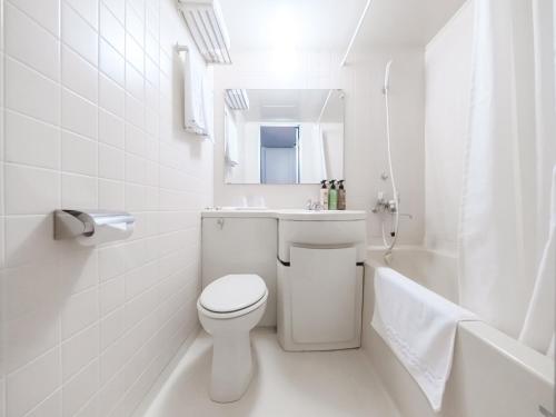 Hotel Tetora Spirit Sapporo - Vacation STAY 59337v في سابورو: حمام ابيض مع مرحاض ومغسلة