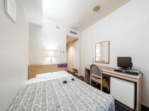 Habitación con cama y escritorio con ordenador. en Hotel Tetora Spirit Sapporo - Vacation STAY 59365v en Sapporo