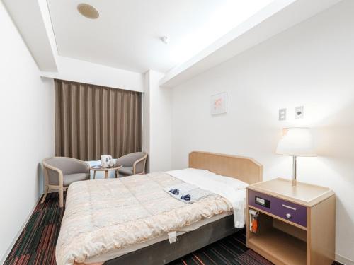 札幌市にあるHotel Tetora Spirit Sapporo - Vacation STAY 59351vのベッド1台と椅子2脚が備わる客室です。