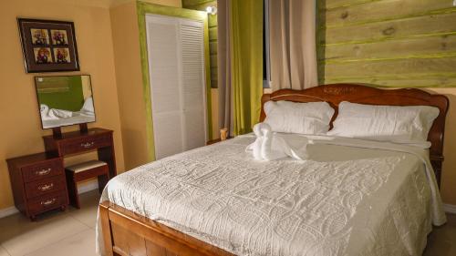 a bedroom with a large bed with a wooden headboard at Incognito Reggae Rooms in Kingston