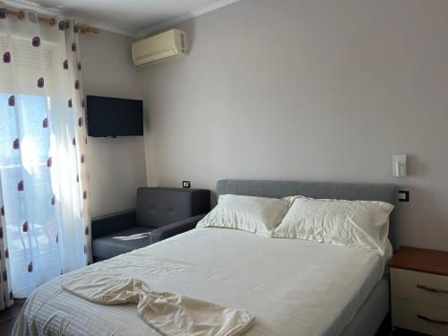 - une chambre avec un lit blanc et un canapé dans l'établissement Waveside Apartment Getaway, à Durrës