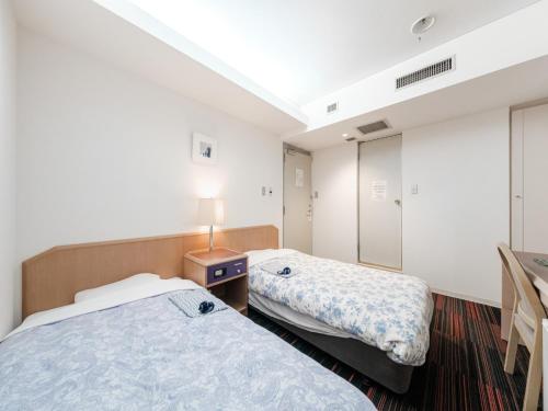 札幌市にあるHotel Tetora Spirit Sapporo - Vacation STAY 59346vのベッド2台と鏡が備わるホテルルームです。