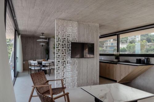 a kitchen and living room with a table and chairs at Mare e Pietra -Pietra Luxury Villa Pefkali in Pefkali