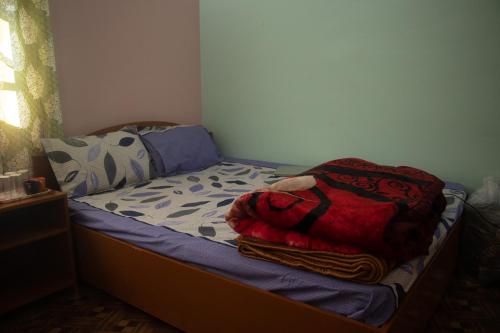 um pequeno quarto com uma cama com lençóis azuis em Malabika Homestay em Padamchen