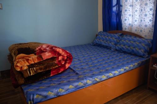 a bed in a room with a blue bedspread on it at Malabika Homestay in Padamchen