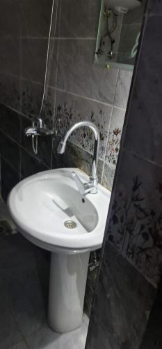 a bathroom with a white sink and a mirror at The Garden Under The Moon in Al Ḩayz