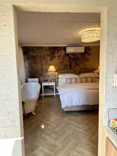 a bathroom with two beds and a bath tub at Môregroet in Kuruman