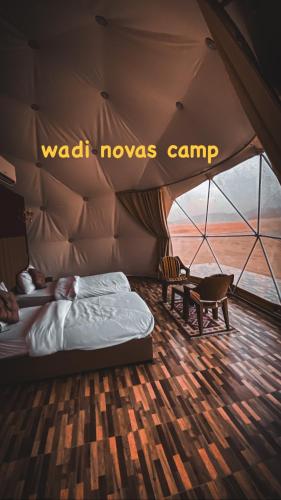 a bedroom in a tent with a bed and a chair at wadi novas camp in Wadi Rum