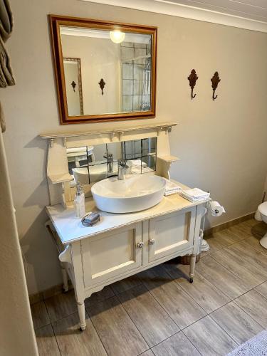 a bathroom with a white sink and a mirror at Môregroet in Kuruman