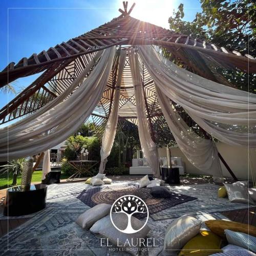 a tent with pillows on a bed in a yard at El Laurel Hotel Boutique in Xochitepec