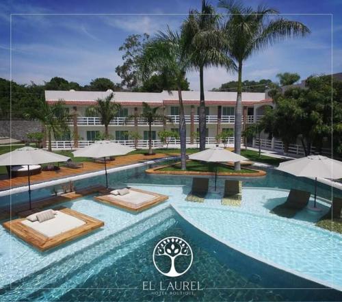 a swimming pool with chairs and umbrellas in front of a building at El Laurel Hotel Boutique in Xochitepec