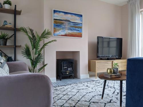 a living room with a fireplace and a tv at Beautifully decorated large family home in seaside town with large garden in Colwyn Bay