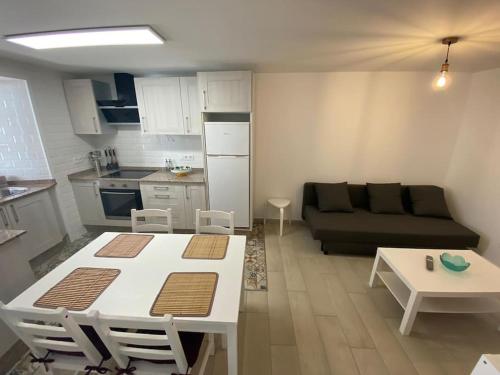 a kitchen and a living room with a couch and a table at Os netos de Fina e Tino in Cariño
