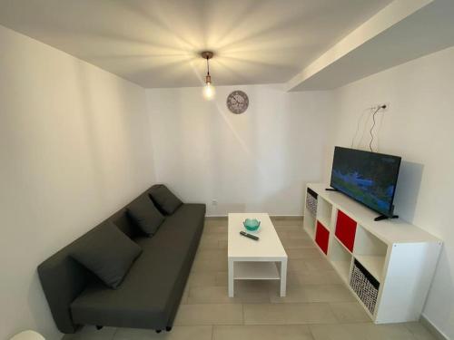 - un salon avec un canapé, une télévision et une table dans l'établissement Os netos de Fina e Tino, à Cariño