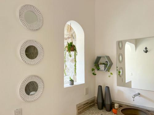 a bathroom with three mirrors and a sink at Villa de Reyes Hotel Boutique in Acapulco
