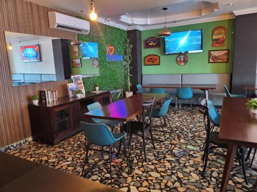 a restaurant with tables and chairs and a tv on the wall at Hotel Via Espana in Panama City