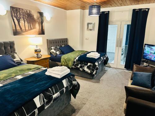 a room with two beds and a tv in it at Modern 2 Bedroom Apt Derby City in Derby