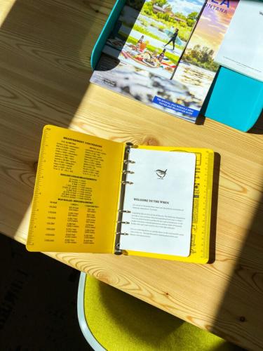 a yellow book sitting on top of a wooden table at The Wren in Missoula