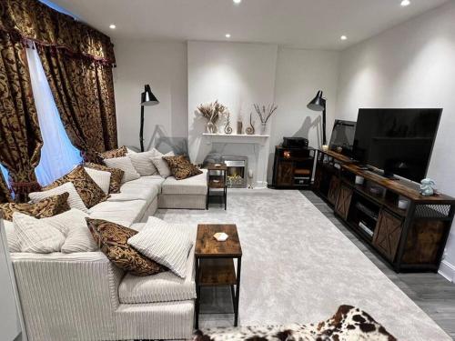 een woonkamer met een bank en een tv bij CozyCube in Croydon