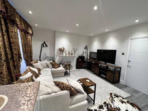 een woonkamer met een bank en een tv bij CozyCube in Croydon