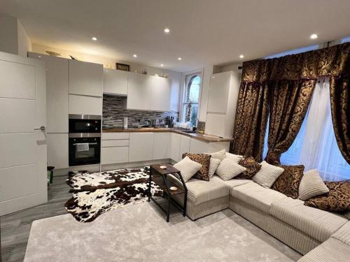 een woonkamer met een bank en een keuken bij CozyCube in Croydon