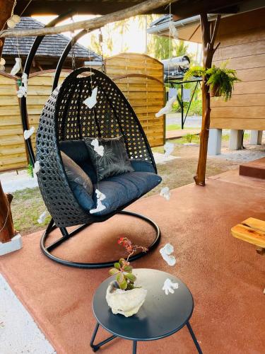 a wicker swing chair on a patio with a table at Bungalow TEIPO in Teavaro