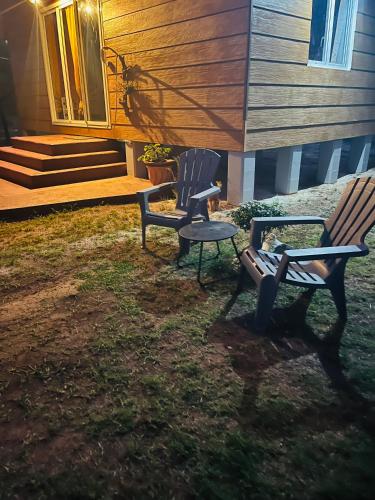 two chairs and a table in front of a house at Bungalow TEIPO in Teavaro