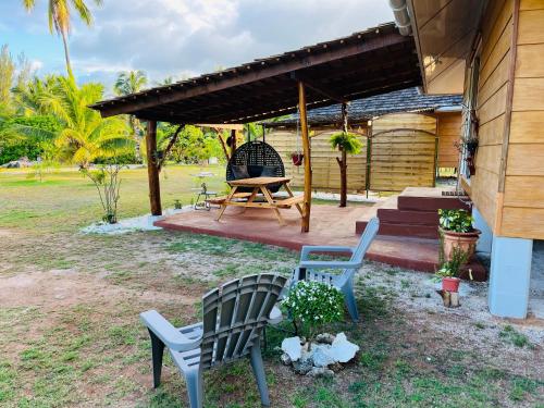 eine Terrasse mit 2 Stühlen und einem Picknicktisch in der Unterkunft Bungalow TEIPO in Teavaro