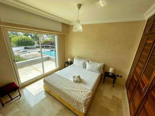 1 dormitorio con cama y ventana grande en Étage de villa entier et indépendant C en Rabat