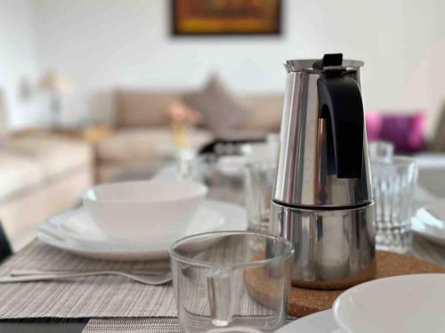 een tafel met een koffiepot en glazen erop bij Étage de villa entier et indépendant C in Rabat