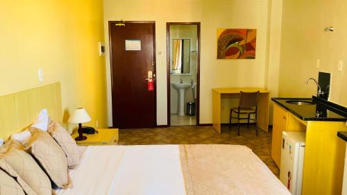 a hotel room with a bed and a bathroom at Hotel Atlantico Macaé By Inn House in Macaé
