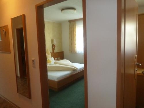 a bedroom with a bed and a mirror at Apart Franz Josef in Stumm