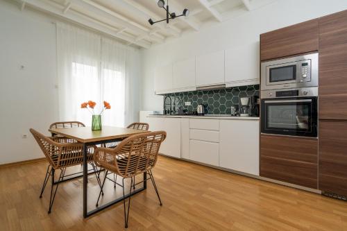 a kitchen with a table and chairs in a room at Athenian Classy 2BD Apt next to Metro Panepistimio in Athens