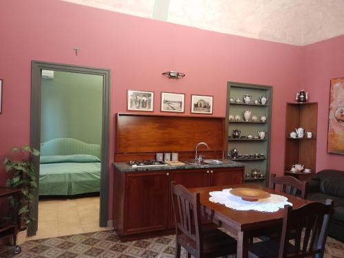 eine Küche mit einem Tisch und einem Waschbecken sowie ein Schlafzimmer in der Unterkunft Casa Castelli Appartamento vacanza in Bagheria