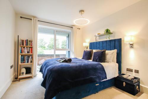 a bedroom with a blue bed and a window at Luxurious 1 Bedroom West Bridgford Apartment in Nottingham