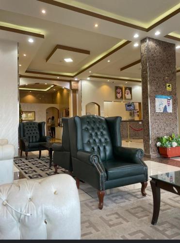 a waiting room with a leather couch and a table at طرف الطريق in Al Ḩawīyah