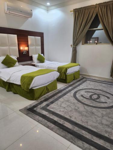 two beds in a hotel room with a carpet at طرف الطريق in Al Ḩawīyah