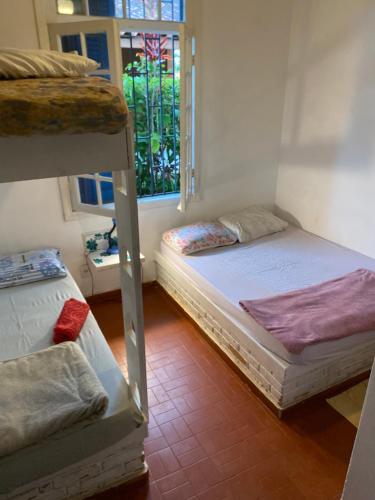 Ce dortoir comprend 2 lits superposés et une fenêtre. dans l'établissement Casa na quadra da Praia do Tenório, à Ubatuba