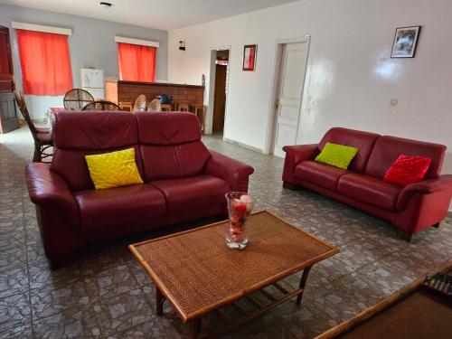 a living room with two red couches and a table at Villa Duchesse in Sali Nianiaral
