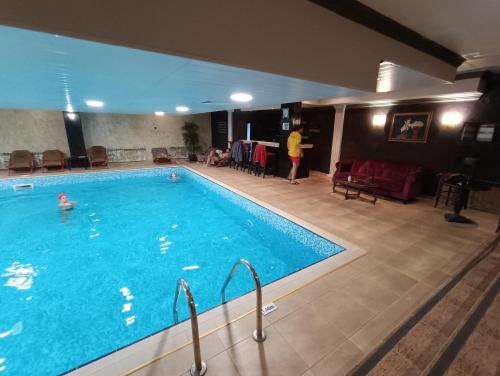 a large swimming pool with a person standing next to it at Viva 3 Grand monastery in Pamporovo