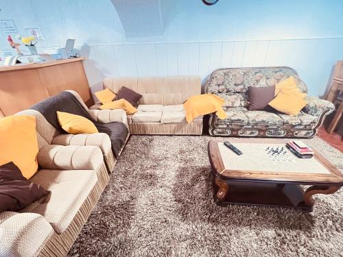a living room with two couches and a table at HOSTEL GOLDEN STAR in Gião
