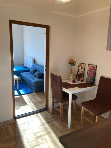a living room with a table and a blue couch at Luks MM 4 in Pančevo