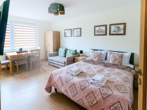 1 dormitorio con 1 cama, 1 mesa y 1 silla en Apartament Sandomierski, en Sandomierz