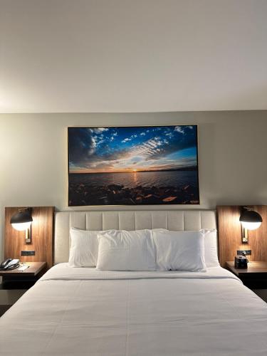 a large white bed in a room with two lamps at La Quinta Inn by Wyndham Columbia NE Fort Jackson in Columbia