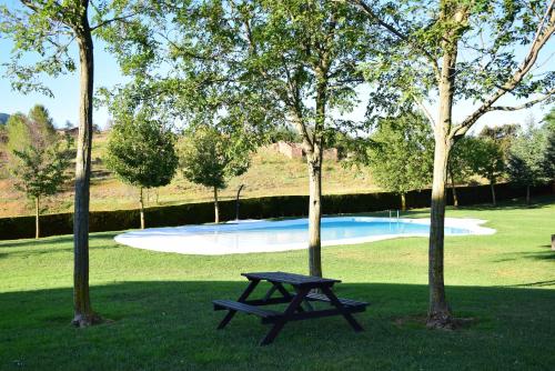 a picnic table in the grass next to two trees at Oasis rural in Los Pastores