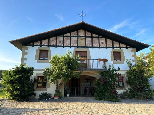 a large white house with a gambrel roof at Caserio Kamirune in Laukiz