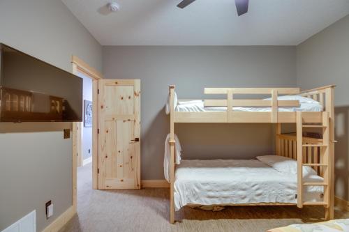 a bedroom with two bunk beds and a door at Pequot Lakes Retreat with Beach and Fire Pit! in Pequot Lakes