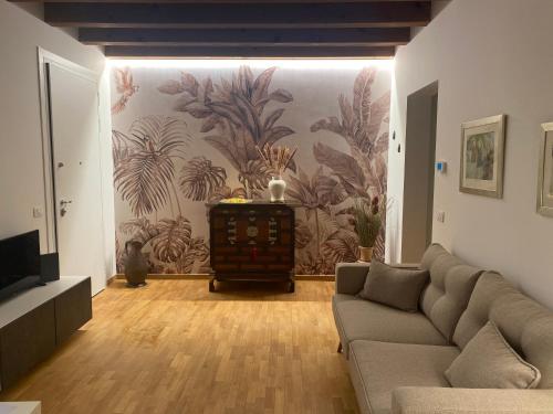 un soggiorno con divano e murale di Appartamento Galilei a Udine