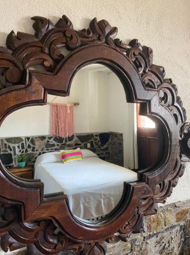 a mirror reflecting a bed in a room at Grann Posada Xilitla in Xilitla